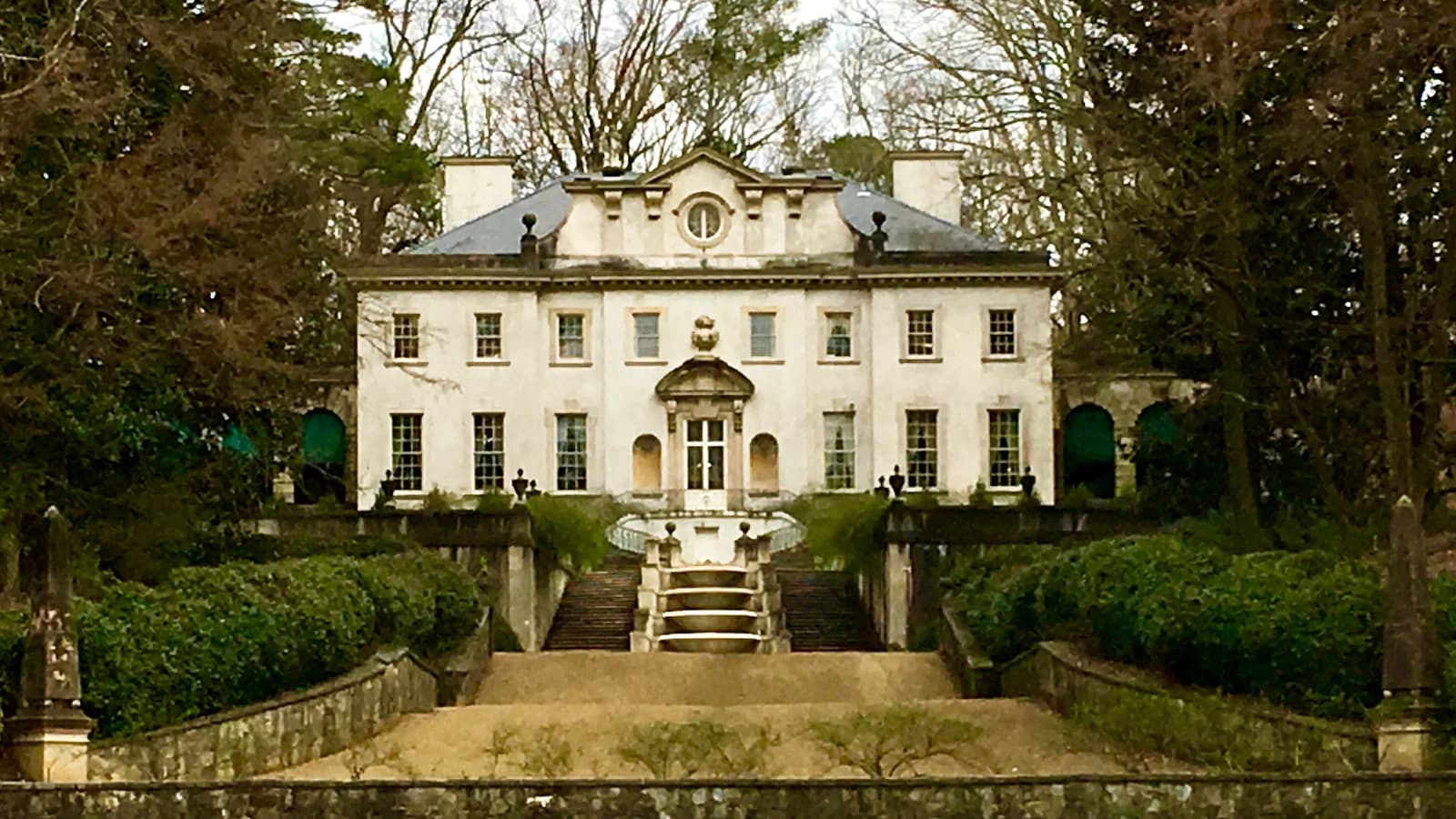 The pale classical facade of Swan House in Atlanta, with stone steps and a cascading fountain lawn in front