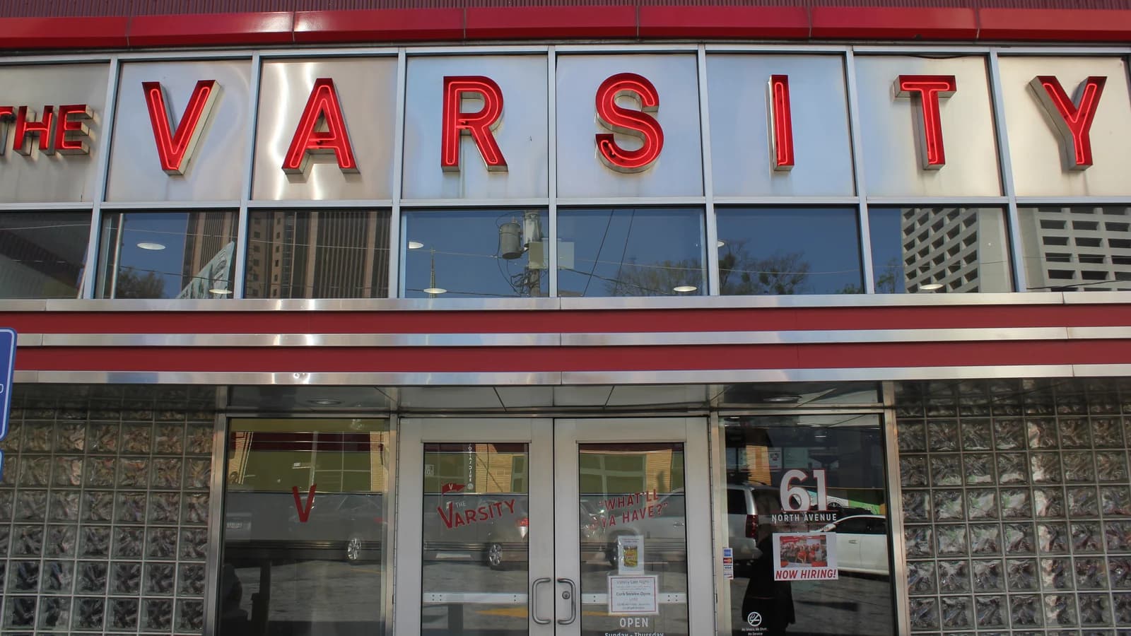 Red letters spelling The Varsity above the steel-trimmed front windows, glass doors and glass-block walls of the restaurant on North Avenue in Atlanta