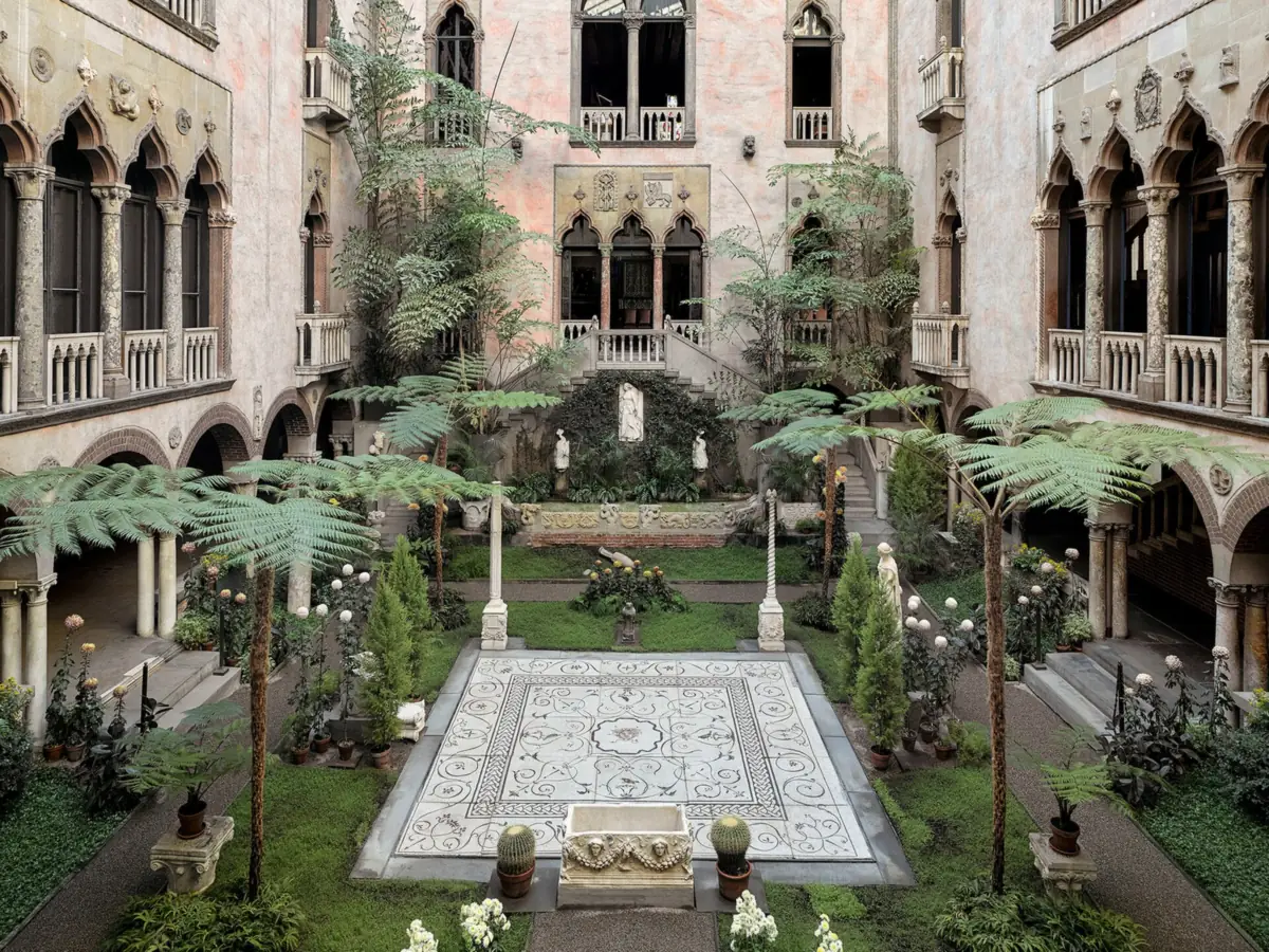 Venetian palazzo courtyard of the Isabella Stewart Gardner Museum seen from an upper floor, with a Roman mosaic floor, ferns, statues and flowering plants