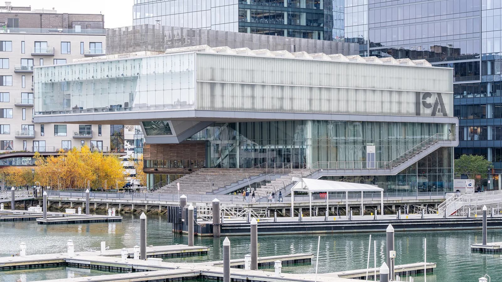 Glass box of the Institute of Contemporary Art cantilevered over the Boston Harbor waterfront, with its wooden harbor steps and boat docks in front
