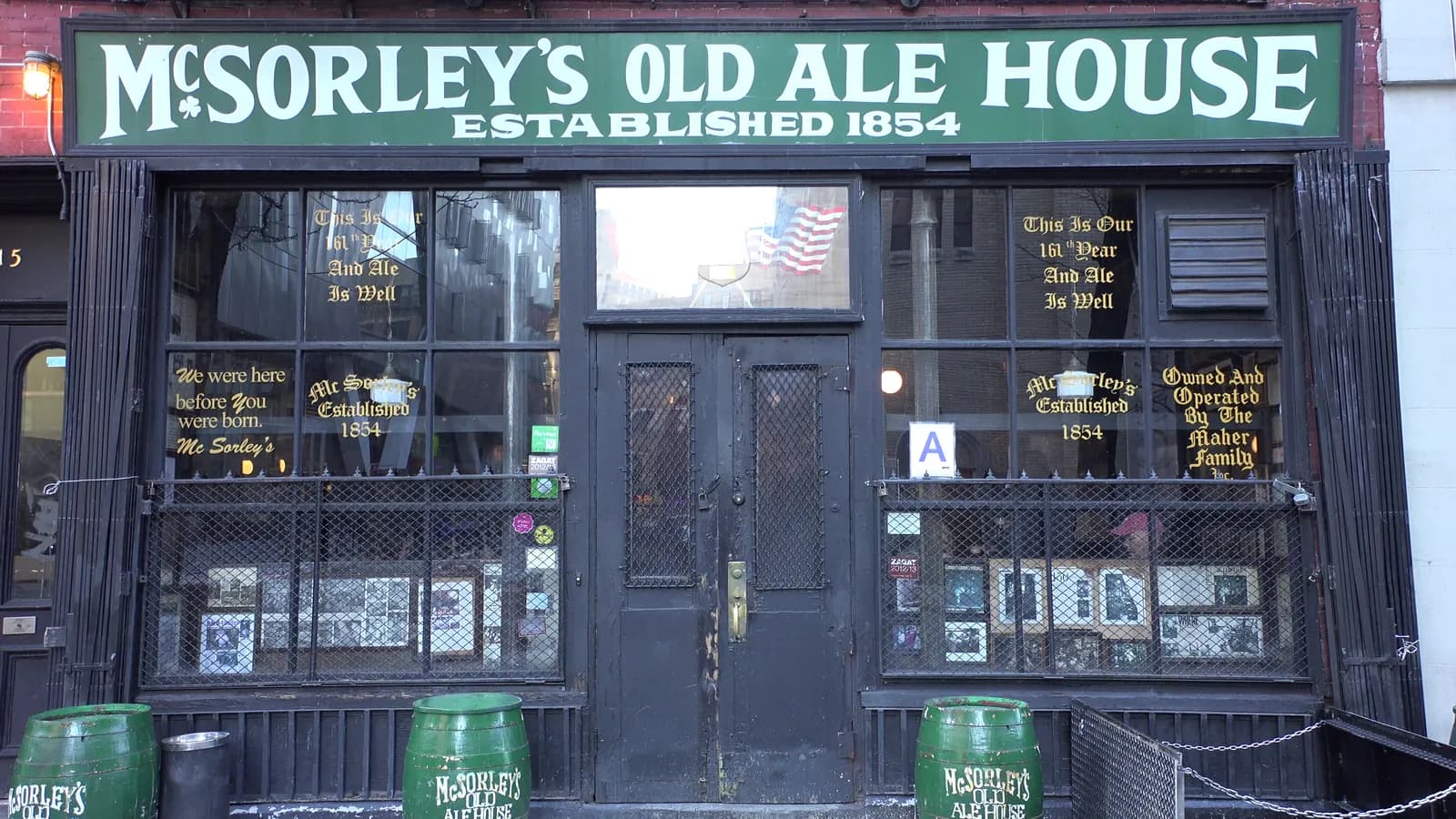 Green McSorley's Old Ale House sign above the dark wooden storefront and ale barrels on East 7th Street