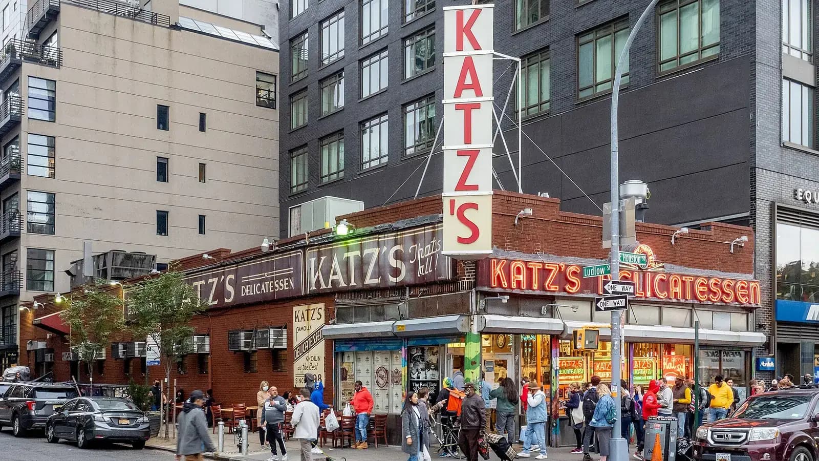 Katz's Delicatessen on the Lower East Side, with its tall vertical KATZ'S sign, neon storefront and a line outside