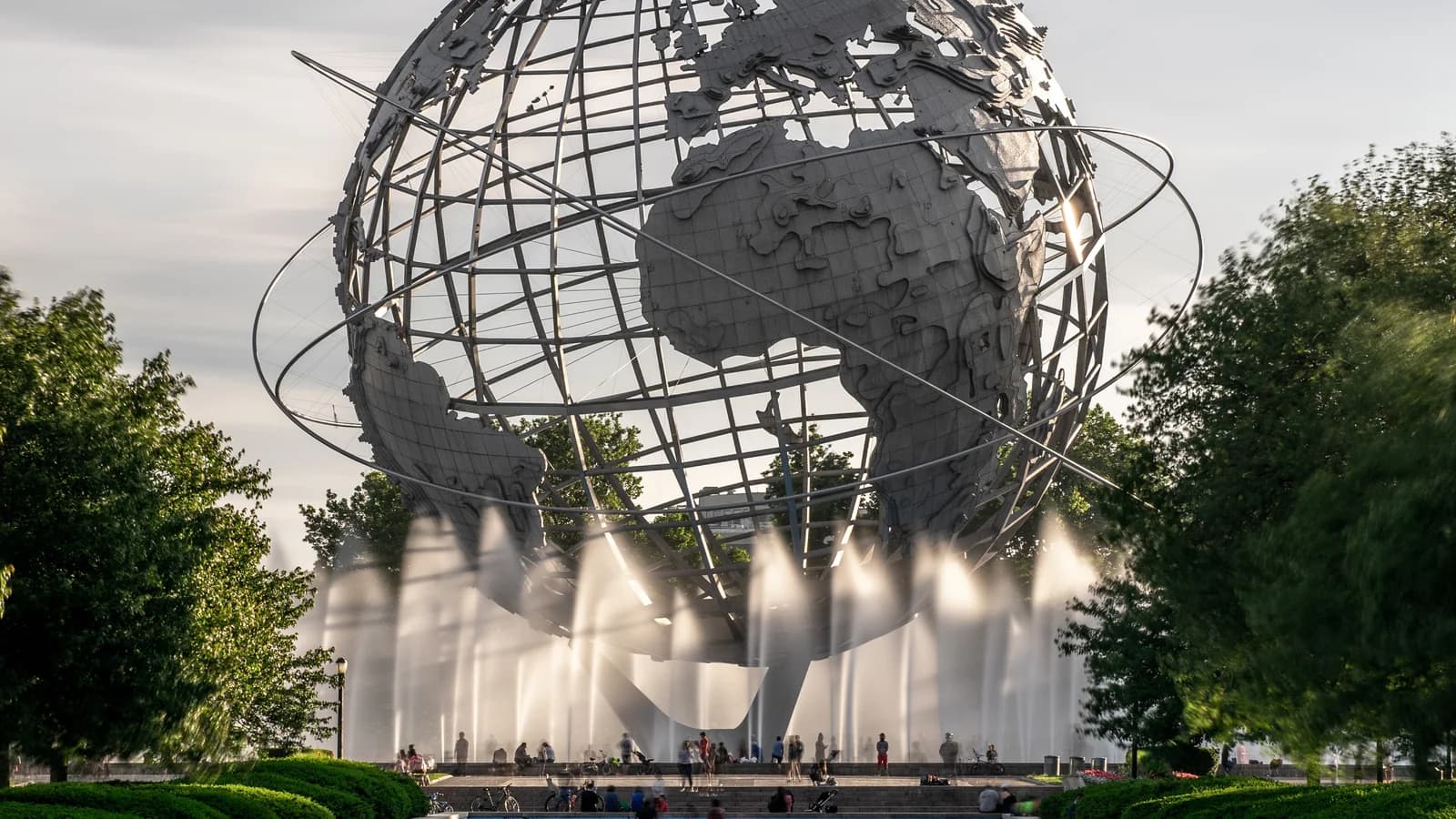 The stainless steel Unisphere globe with its fountains running in Flushing Meadows Corona Park, framed by green trees
