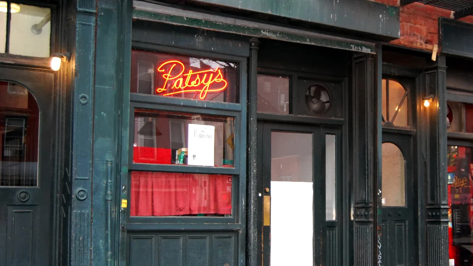 Red Patsy's neon sign glowing in the window of the green-painted storefront on First Avenue in East Harlem