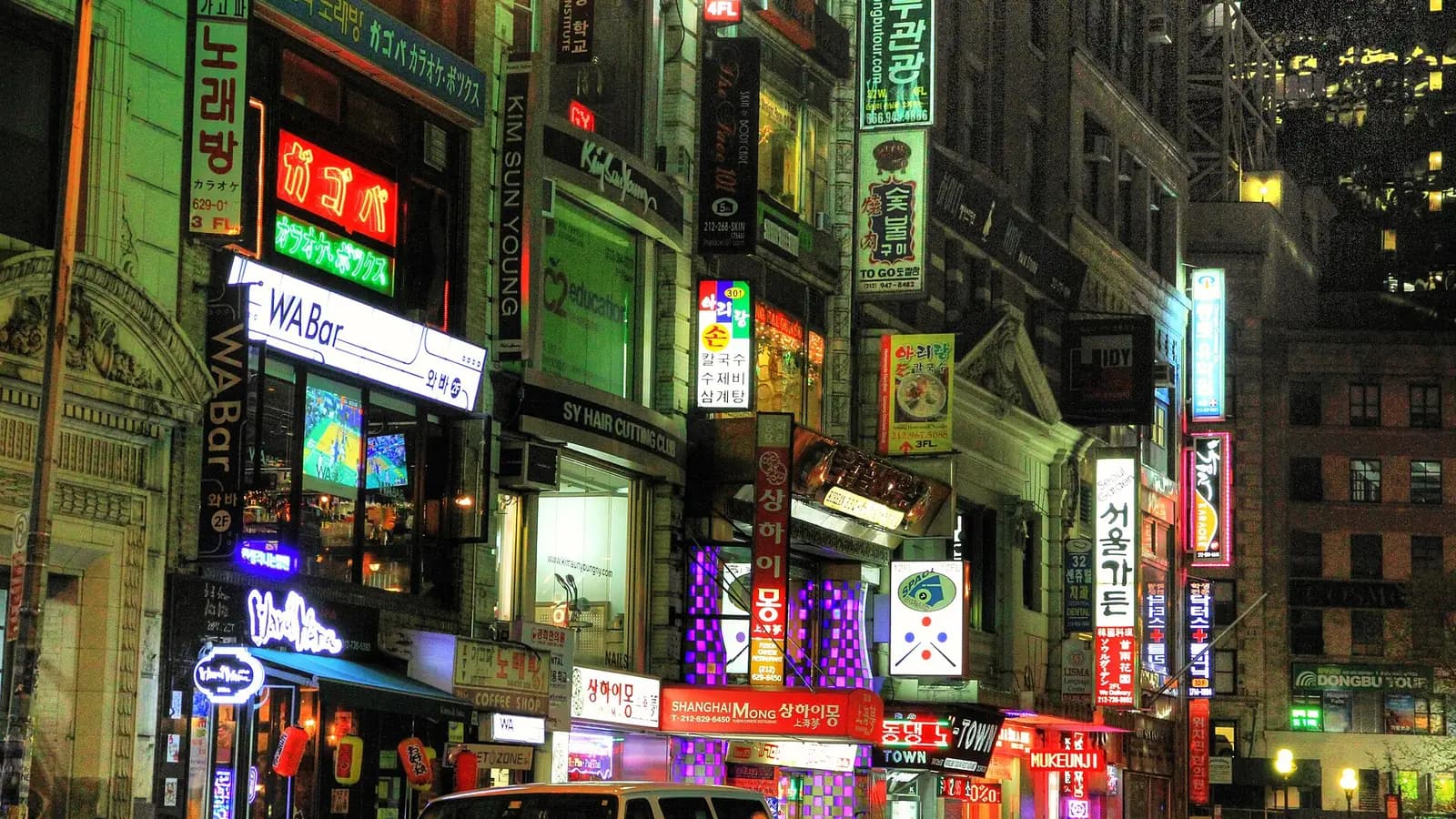 Neon Korean signs stacked up the buildings on West 32nd Street in Manhattan Koreatown at night