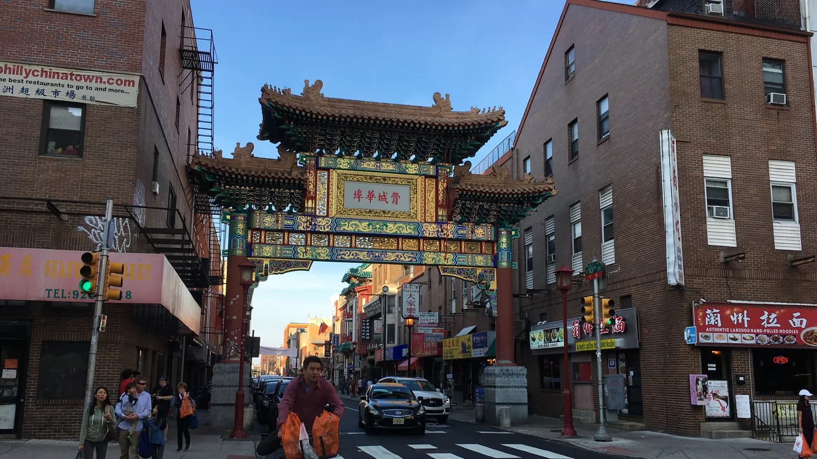 Painted Chinatown Friendship Gate arching over 10th Street between brick shops with Chinese signs