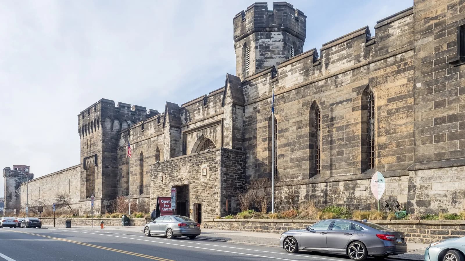 Castle-like stone walls and guard tower of Eastern State Penitentiary beside the street