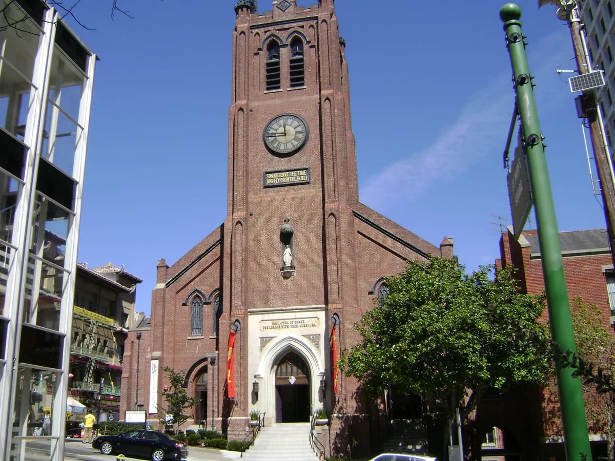 Old St. Mary's red brick Gothic church with its square clock tower, the clock above a plaque reading Son, observe the time and fly from evil, and a white arched doorway