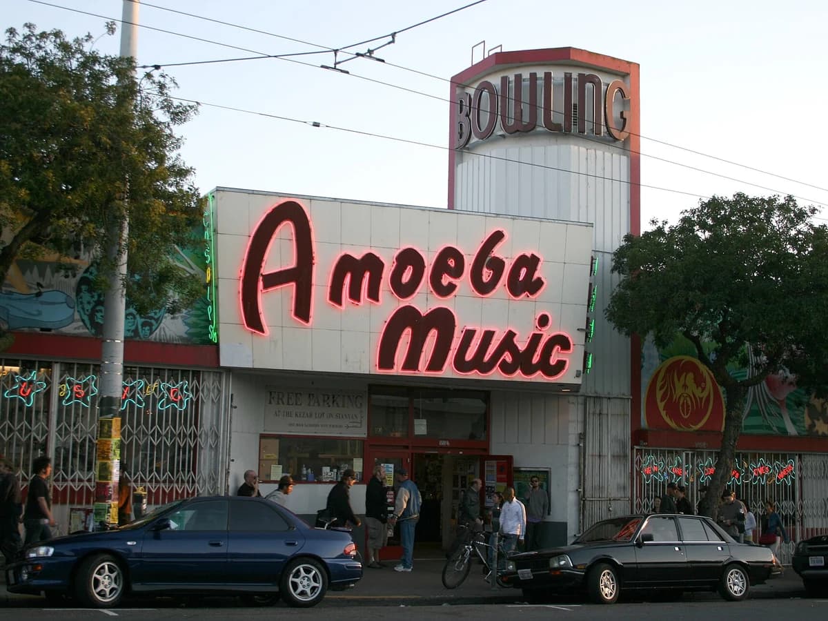Amoeba Music's storefront on Haight Street with its big red Amoeba Music sign and the old Bowling tower above, cars parked out front