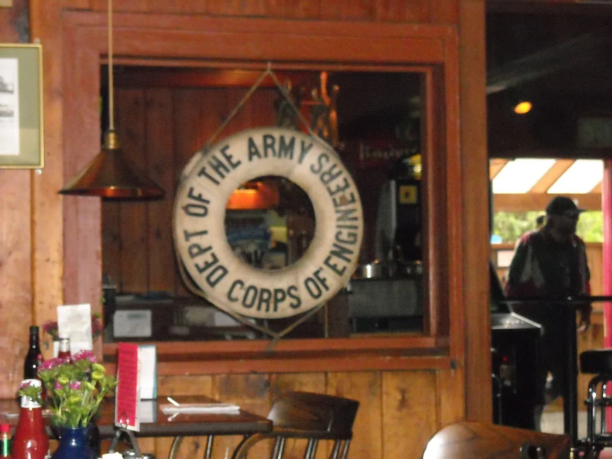 Inside the Lockspot Cafe, an old life ring marked Department of the Army Corps of Engineers hangs in a wooden window frame above a counter
